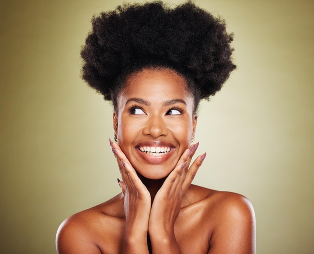 Черная женщина с афро-волосами или думает о захватывающих идеях на фоне зеленой студии на фоне здравоохранения, велнеса, любви к себе или ухода за кожей. Улыбайтесь счастливой или вдохновленной моделью красоты, натуральными волосами или косметикой для макияжа.