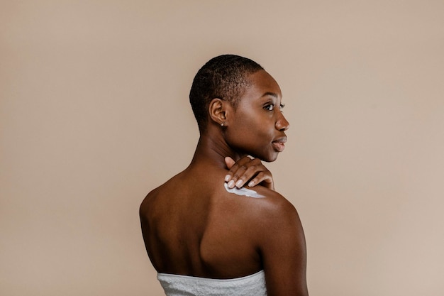 Photo black woman applying body cream