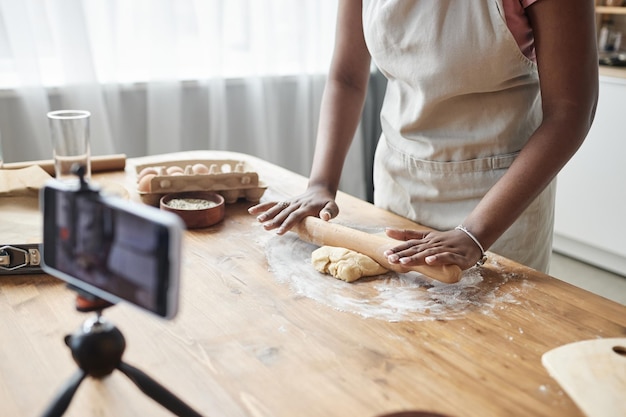 Black woman baking homemade pastry recording video or livestream