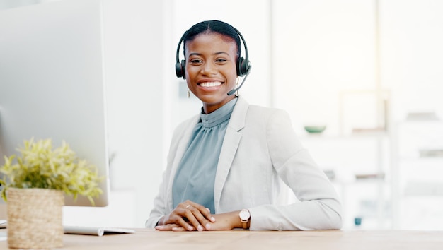 흑인 여성 콜센터와 텔레마케팅 고객 서비스 또는 지원에서 컴퓨터 위에서 미소를 지으며 사무실 책상에서 도움이나 조언을 얻기 위해 헤드셋을 착용한 행복한 아프리카계 미국인 여성 컨설턴트 에이전트의 초상화