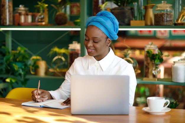カフェに座ってラップトップを使用して黒人女性起業家