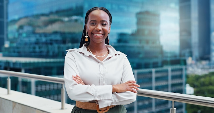 Photo black woman face and arms crossed lawyer happy with career and confident on rooftop skyscraper and pride expert legal employee or attorney with smile in portrait for corporate and professional