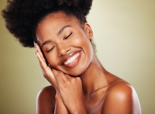 Black woman hands and smile for facial skincare makeup or cosmetics against a studio background African American female smiling in satisfaction for beautiful cosmetic treatment or perfect skin