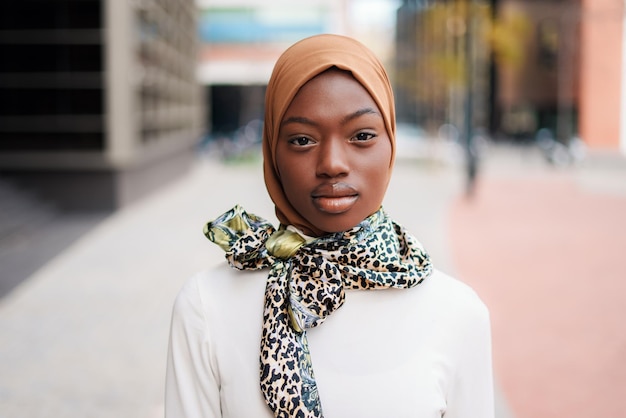 Black woman in hijab and scarf standing on street