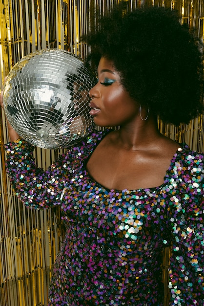 Фото Черная женщина держит диско-шар среднего выстрела