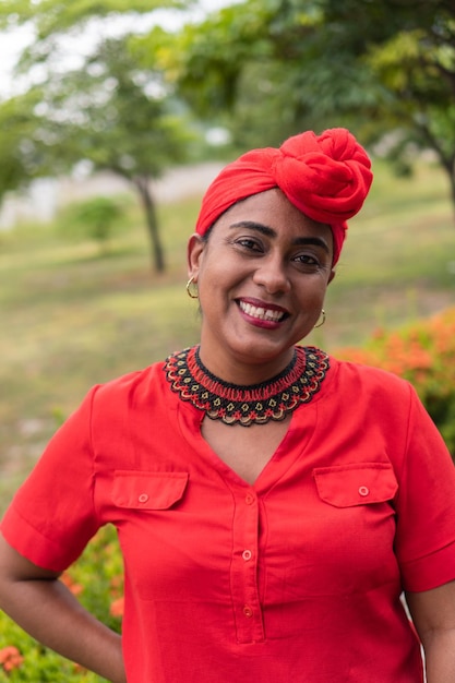 Black woman looking at camera with a turban in park