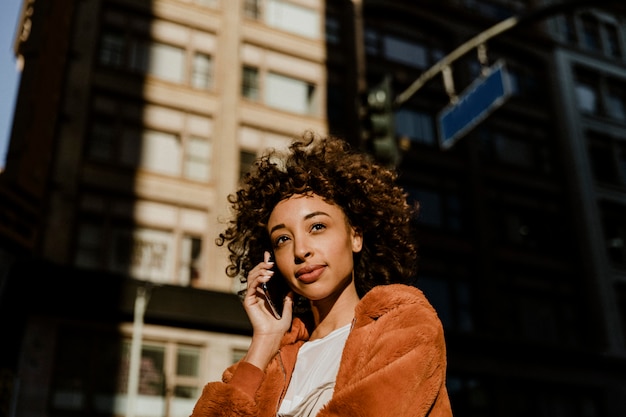 Black woman making a call in downtown