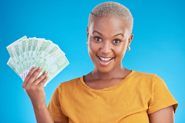 Black woman money fan and finance portrait and happy with prize loan and dollars isolated on blue background Cash cashback and lottery win with payment financial freedom and bills in studio