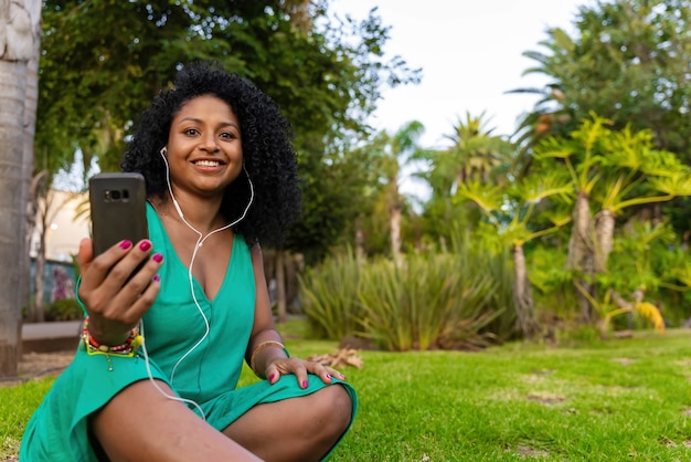 Donna di colore nel parco con videochiamata