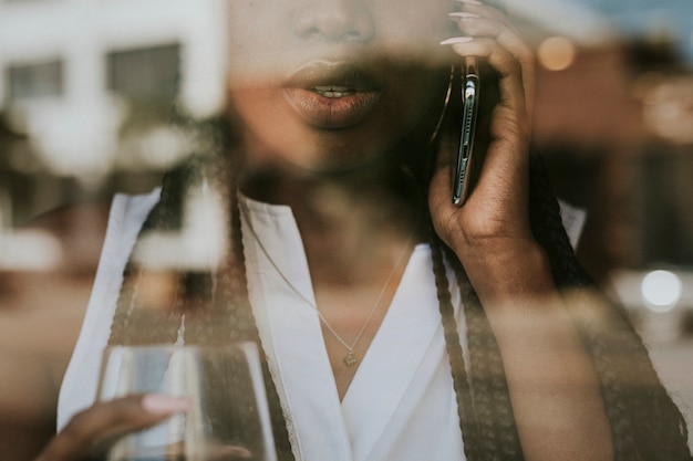 Black woman on the phone looking out the window