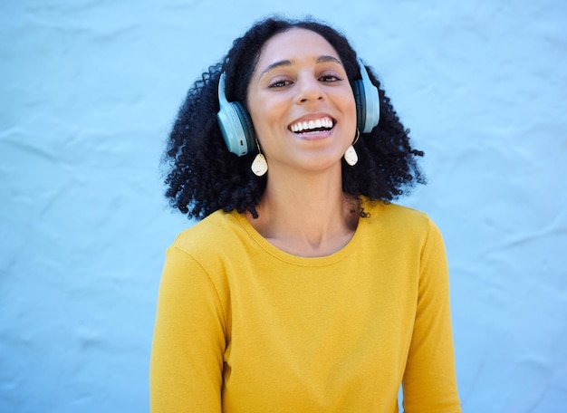 Photo black woman portrait or music headphones on isolated blue background fashion mockup or wall mock up smile happy or laughing student listening to radio audio and podcast in trendy or cool clothes