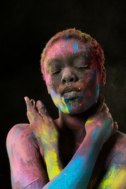 Photo black woman posing with colorful powder medium shot