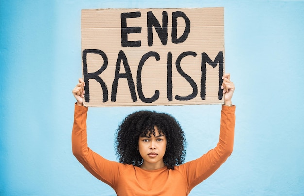 Photo black woman protest poster and anger at racism fight for equality human rights and freedom isolated on blue background global problem social justice and revolution angry in studio and politics