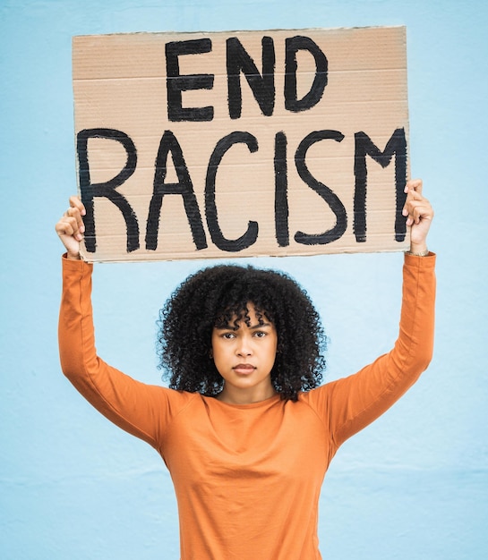 Photo black woman protest poster and angry at racism fight for equality human rights and freedom isolated on blue background global problem social justice and revolution anger in studio and politics