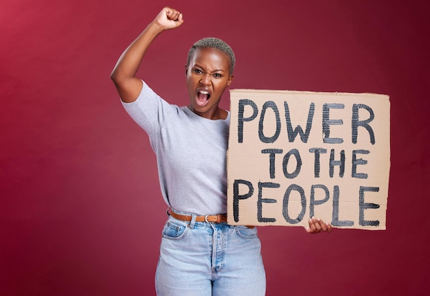 Foto protesta della donna nera e poster per il potere e l'uguaglianza dei diritti umani o chiedendo cambiamento e libertà per fermare il razzismo la donna africana grida lotta e vota mentre tiene un cartello di cartone e un pugno