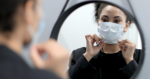 Photo black woman putting on face mask against virus bacteria prevention outbreak