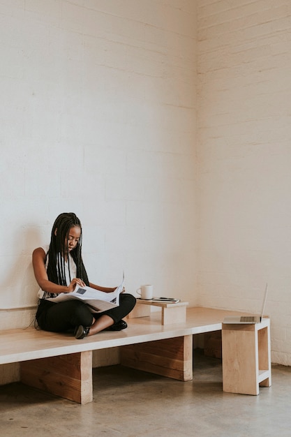 Black woman reading a newspaper in a cafe