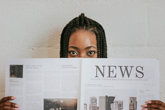 Photo black woman reading a newspaper