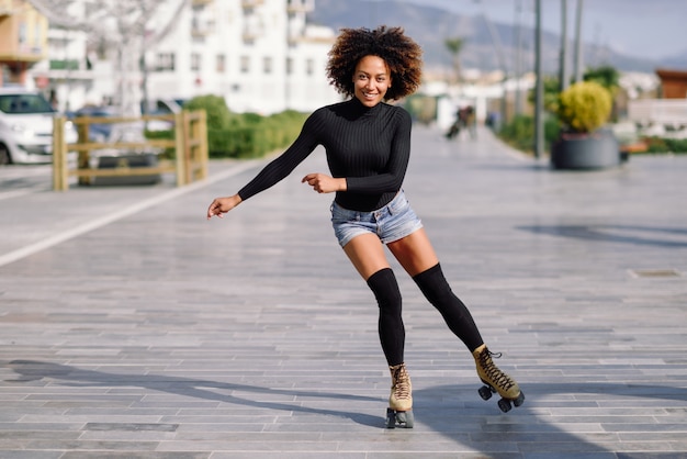 도시 거리에 야외에서 타고 롤러 스케이트에 흑인 여성