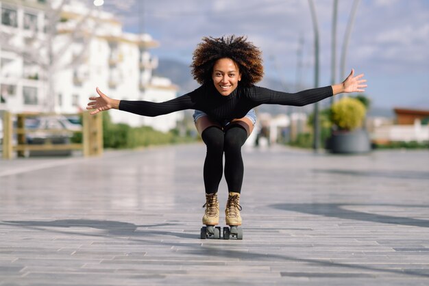 Black woman on roller skates riding outdoors on urban street