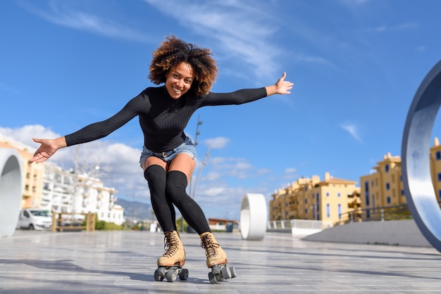 Black woman on roller skates riding outdoors on urban street