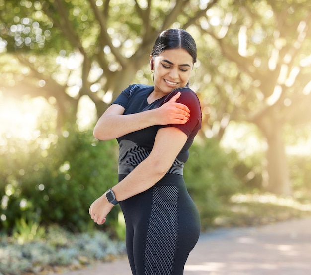 Black woman runner and muscle pain in arm while outdoor for fitness workout or exercise in park Woman running and training for healthy body with sore strain or injury on path massage for care