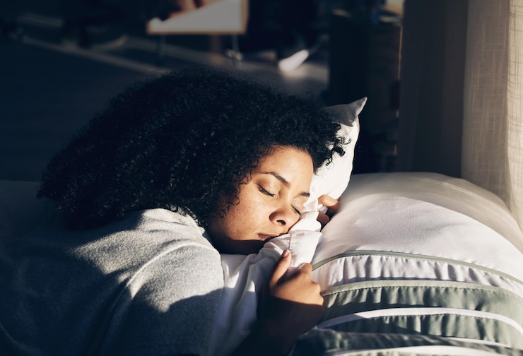 Photo black woman sleeping in bed for peace quiet and rest or relax in home bedroom person with pillow to dream or for calm sleep with sunlight for health and wellness in apartment or hotel