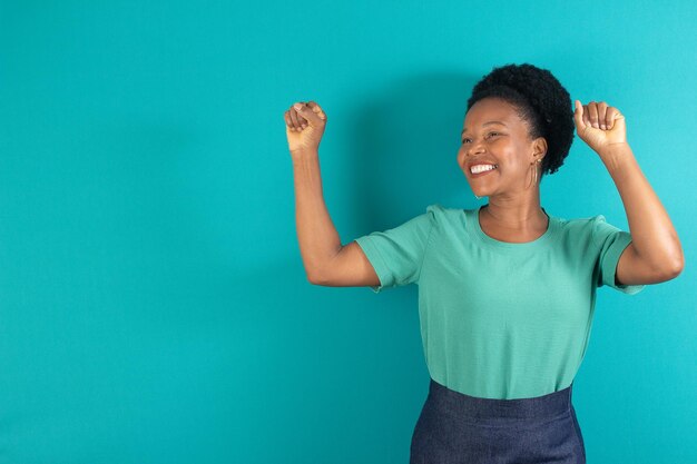 Black woman smiling and making a gesture with a green background