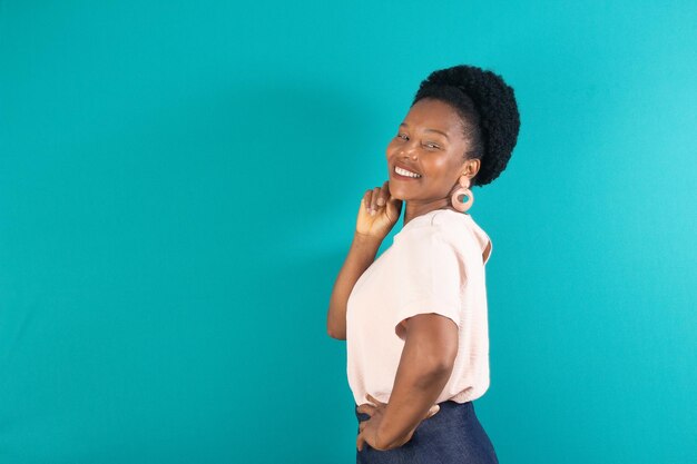 Black woman smiling and making a gesture with a green background