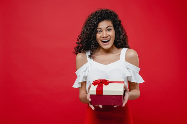 Черная женщина улыбается с подарочной коробке с лентой