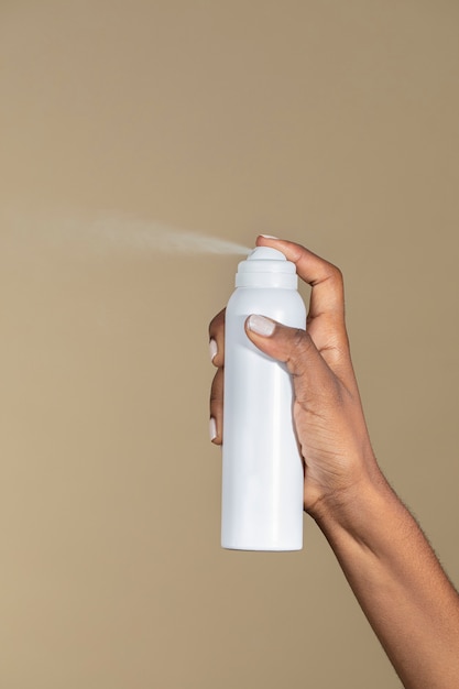 Black woman spraying an unlabeled spray bottle