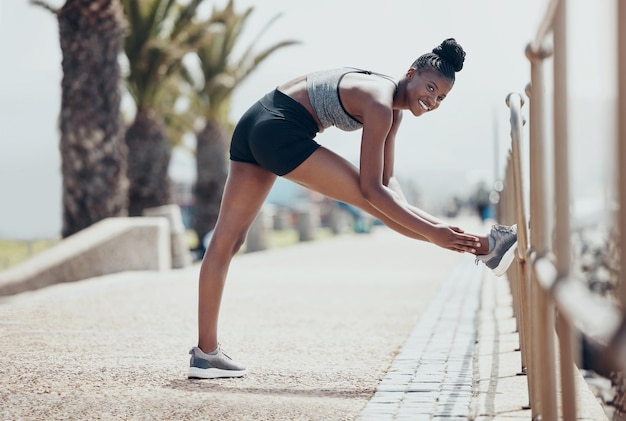 Black woman stretching and exercise for run workout and fitness outdoor in street in sunshine Girl happy and runner warmup to start training for race marathon or competition in Cape Town