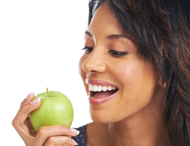 Черная женщина-студия и яблоко с диетическим образом жизни и жаждущие здоровых органических закусок и еды на белом фоне Женщина улыбается и натуральные зеленые фрукты для детоксикации энергии или хорошего самочувствия на заднем плане