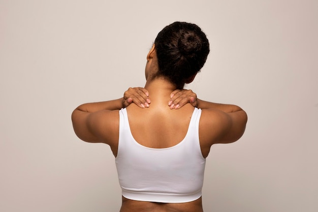 Black woman suffering from pain massaging neck