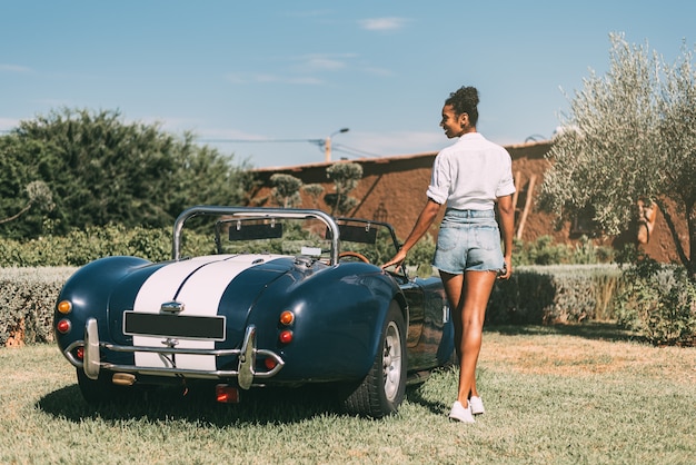 Black woman and vintage convertible car