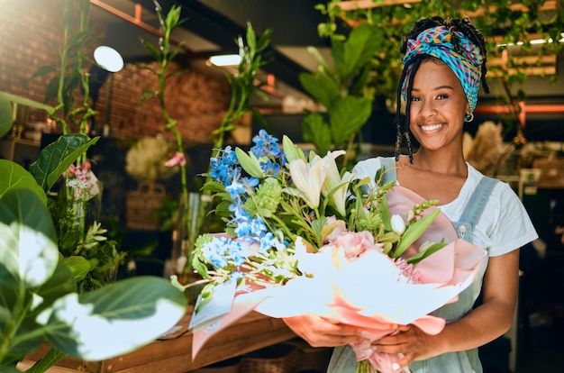 Donna di colore con bouquet di fiori e fioraio in serra piccolo imprenditore e sorriso in ritratto felicità natura e imprenditore con composizione floreale primavera e visione con leadership