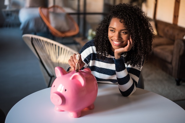 Black woman with saving piggy bank