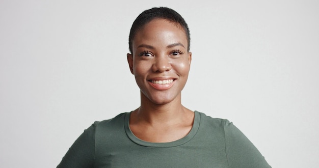 Black woman with a short haircut in studio shootsmiling and wearing dress