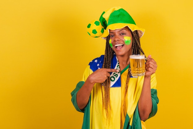 Black woman young brazilian soccer fan drinking beer and celebrating