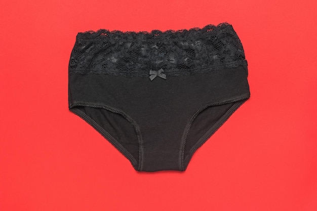 Black women\'s highwaisted panties on a bright red background\
minimal concept of women\'s underwear