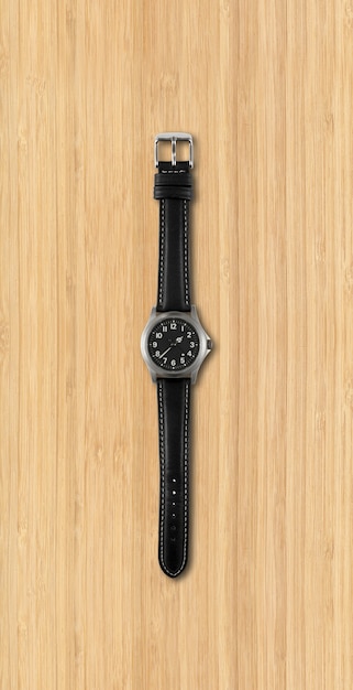 Black wrist watch isolated on wooden