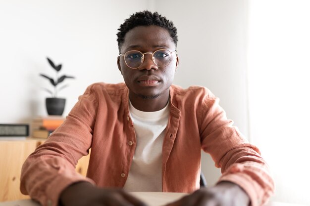 Photo black young man looking at camera with serious expression during video call