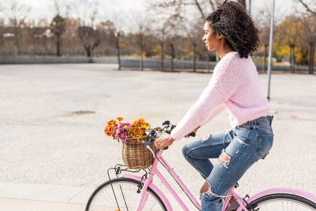 Photo black young woman riding a vintage bicycle