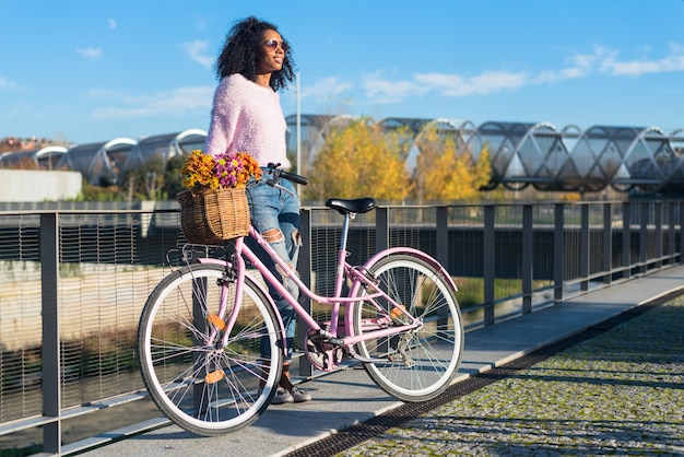 Black young woman riding a vintage bicycle