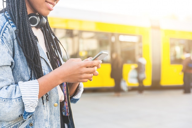 Black young woman typing on smart phone in Berlin