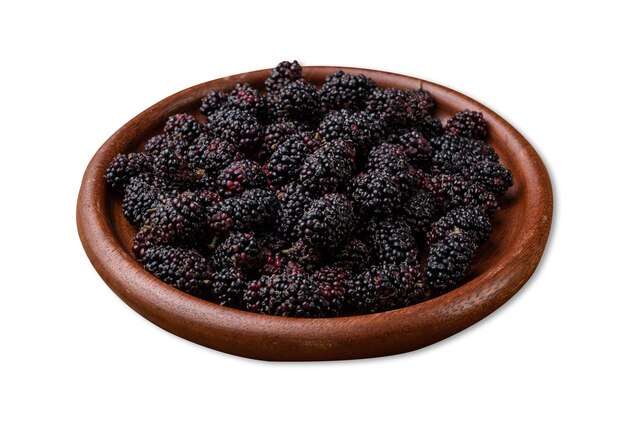 Photo blackberries in a plate over wooden table isolated over white background