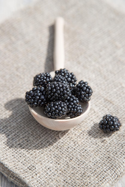 Blackberries in a wooden spoon Vertical orientation Close up