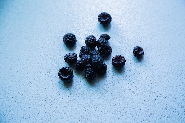 Photo blackberry berries stacked in a pyramid on a light background