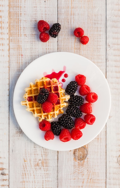 Blackberry and raspberry with a waffle on a white plate