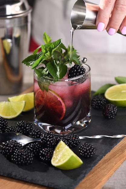 Blackberry zomer mojito cocktail. Koude verfrissende biologische alcoholische drank met bessen, limoen, munt